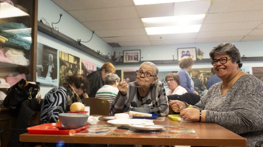 Older adults eat together at West Neighbourhood House