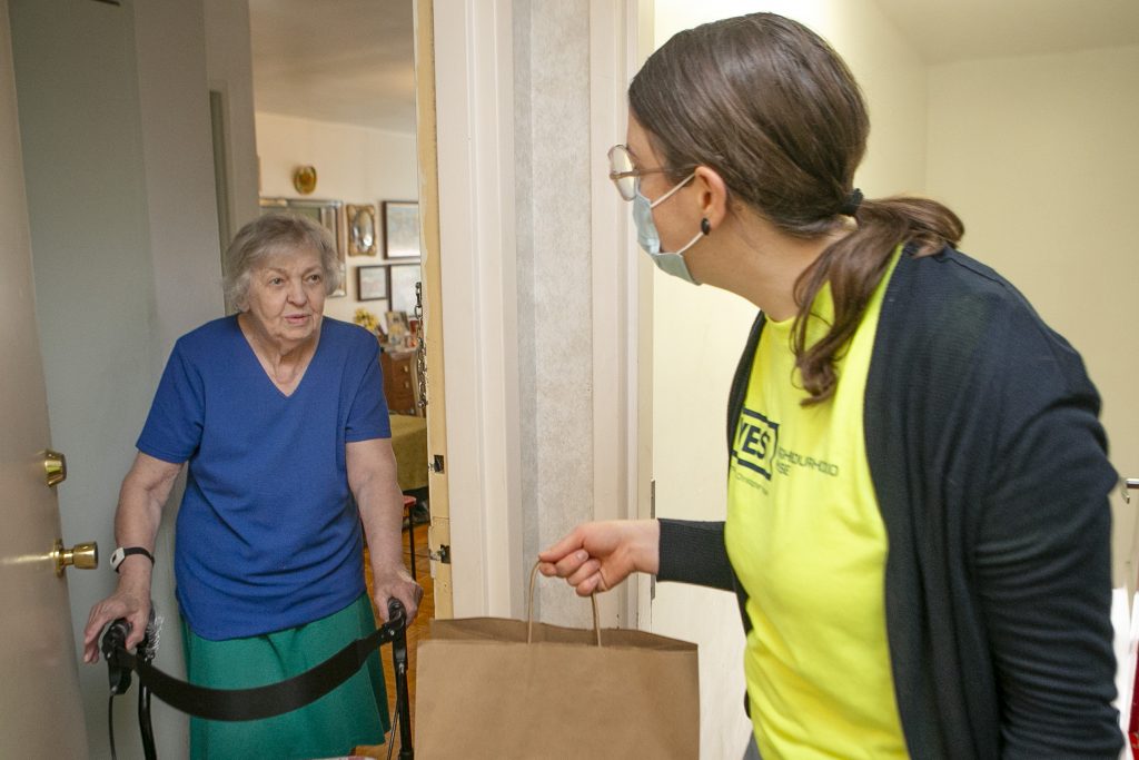 A Meals on Wheels volunteer delivers a meal to an older adult during the COVID-19 pandemic